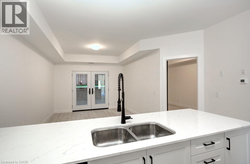 A white kitchen with a sink and a window.