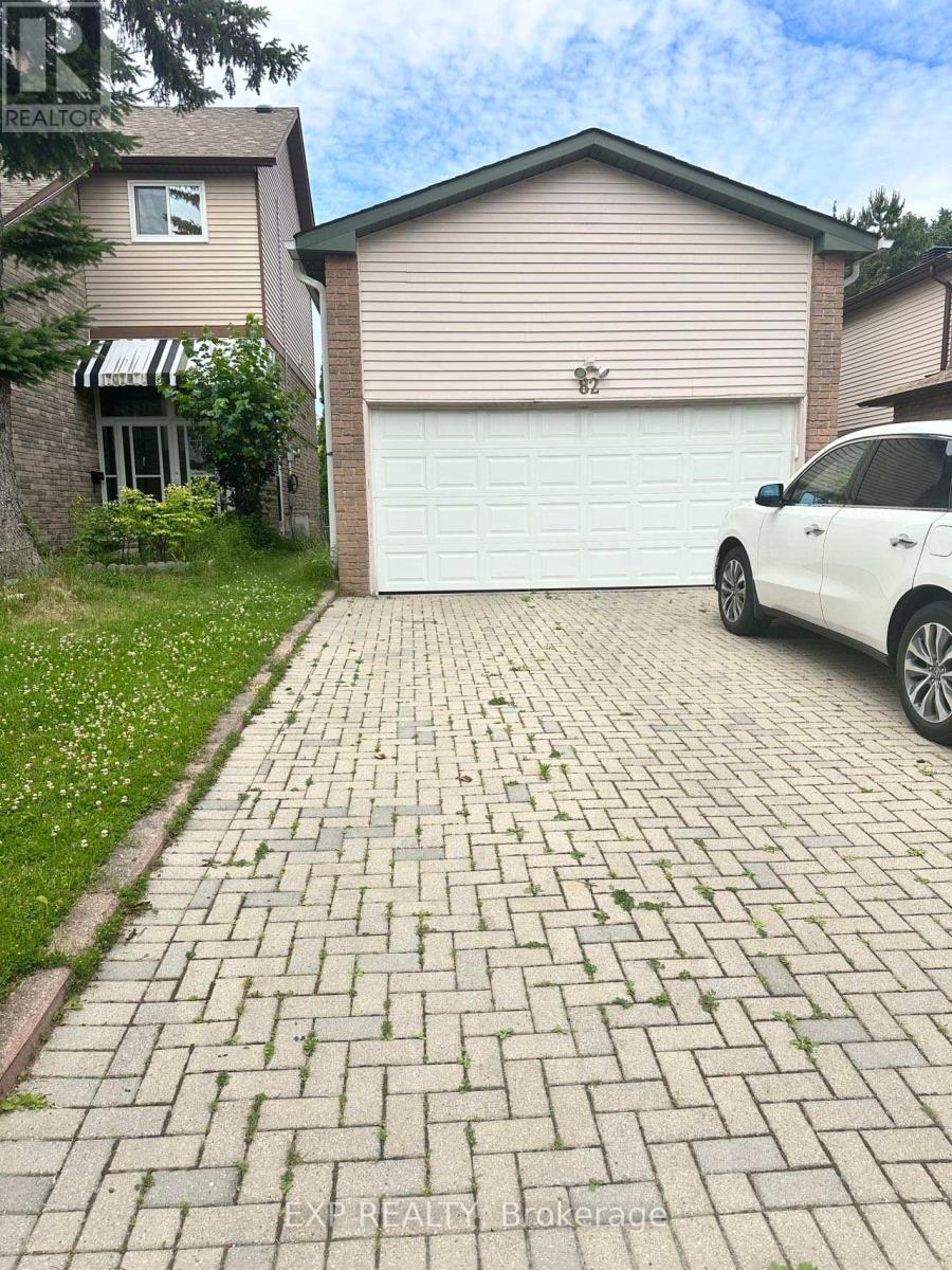 A white car is parked in front of a garage.