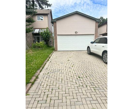 A white car is parked in front of a garage.
