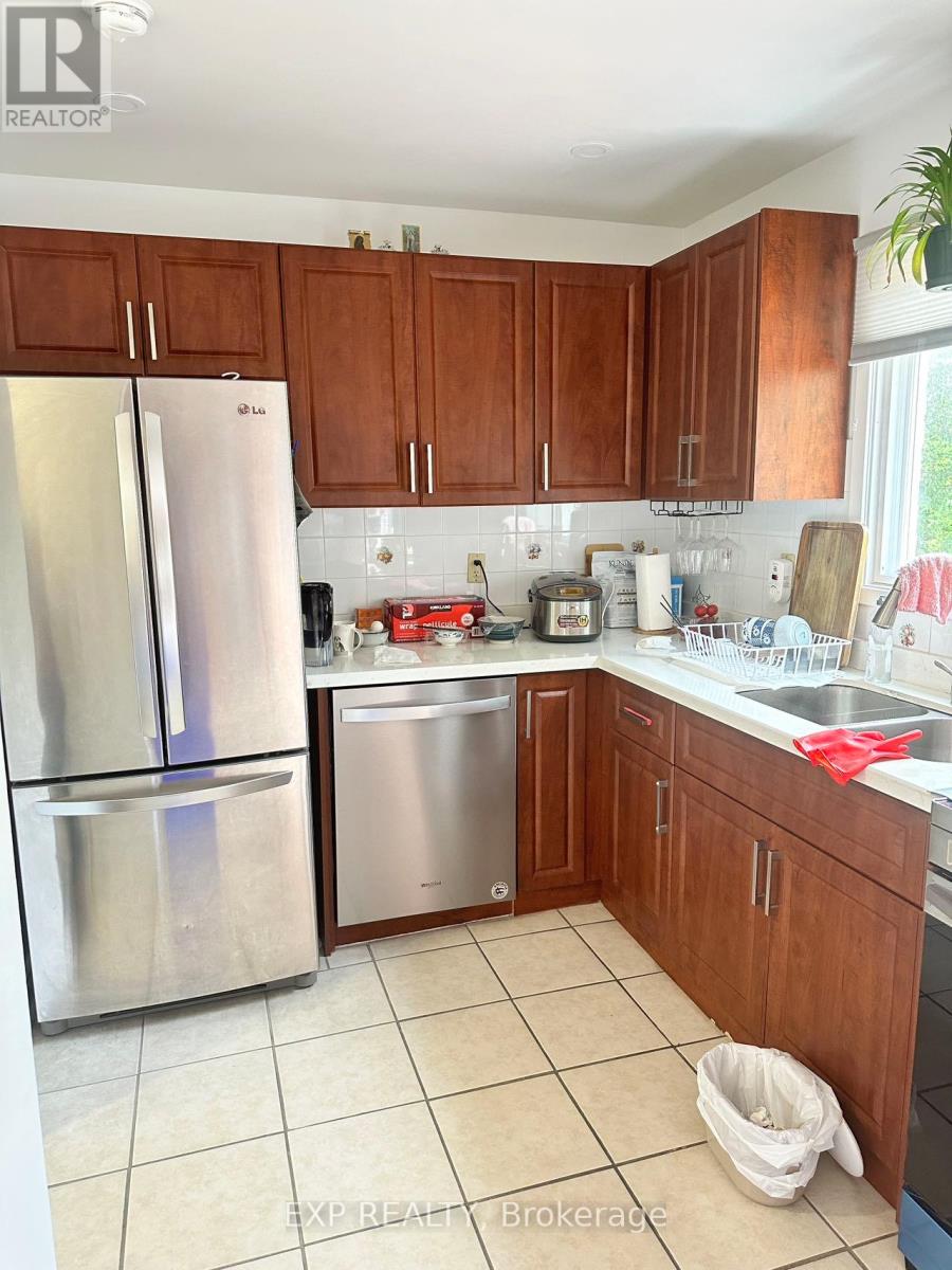 A kitchen with a stainless steel refrigerator and wooden cabinets.