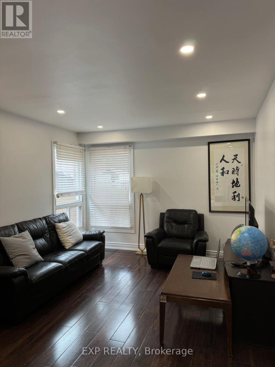 A living room with a black couch, a black chair, and a wooden coffee table.