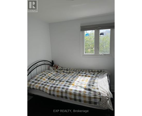 A bedroom with a bed and a window.