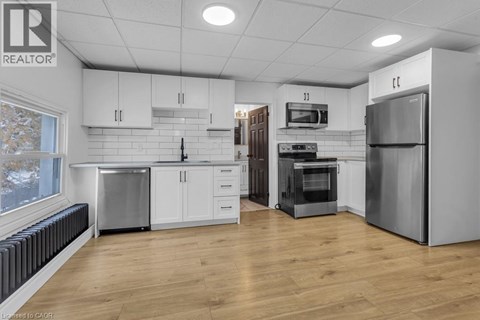 A spacious kitchen with white cabinets and stainless steel appliances.
