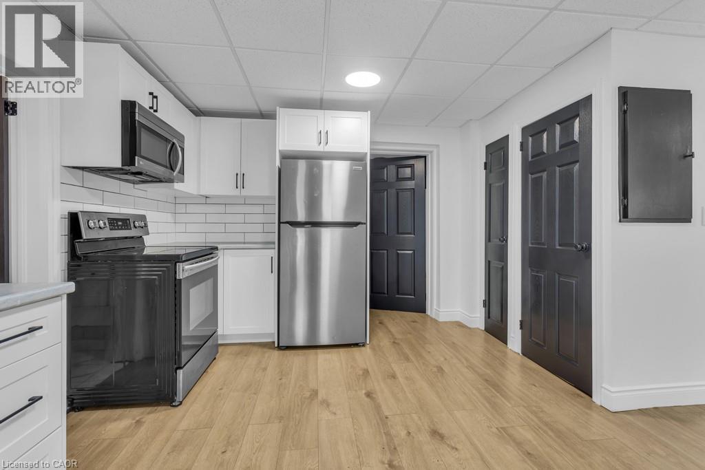 A kitchen with a refrigerator, oven, and microwave.