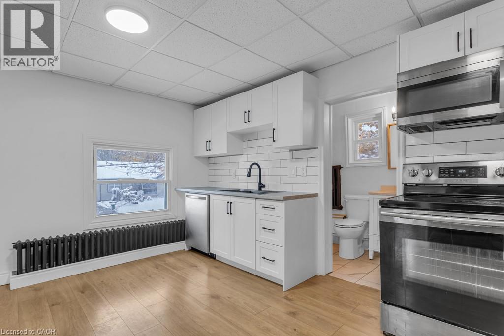 A white kitchen with a black stove top oven.
