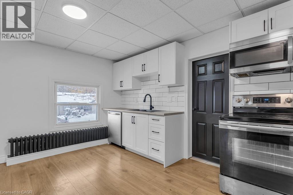 A modern kitchen with white cabinets and stainless steel appliances.