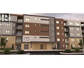 A modern apartment building with balconies and a small courtyard in front.