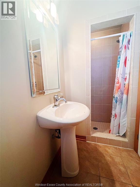 A white pedestal sink with a mirror above it.