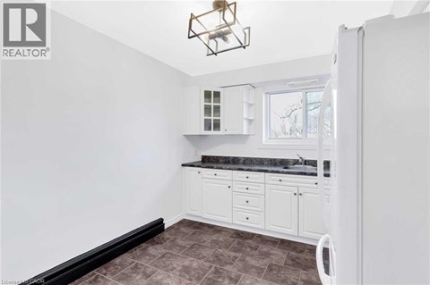 A kitchen with white cabinets and a black countertop.