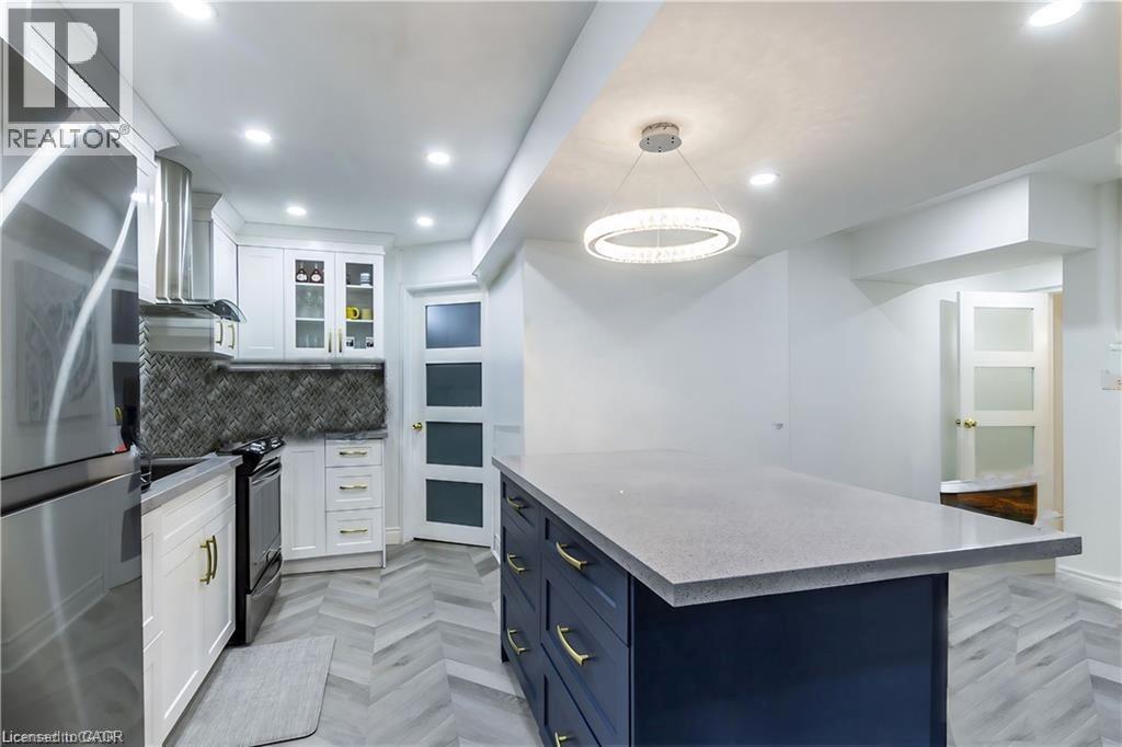 A modern kitchen with a large island and stainless steel appliances.