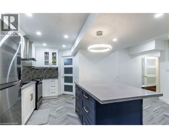 A modern kitchen with a large island and stainless steel appliances.