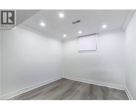 A room with a window and a wooden floor.