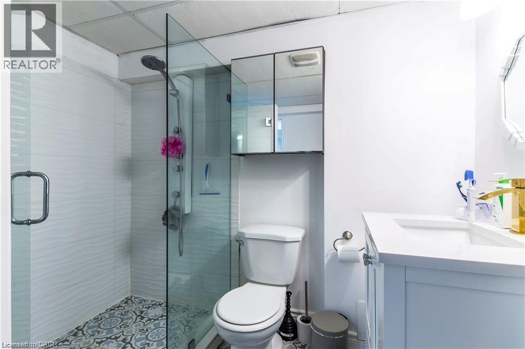 A white toilet with a glass shower stall in the background.