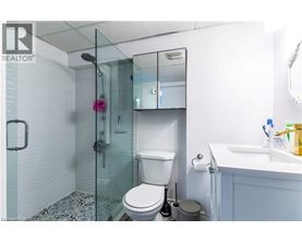 A white toilet with a glass shower stall in the background.