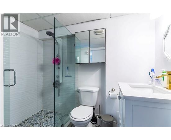 A white toilet with a glass shower stall in the background.
