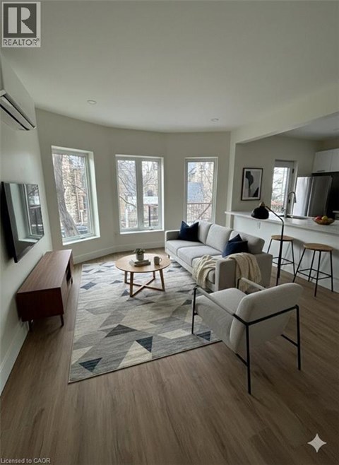 A living room with a grey sofa and a rug with a geometric pattern.