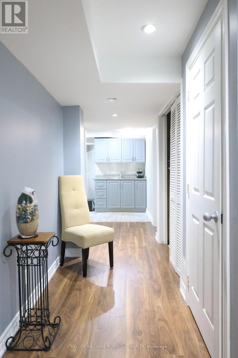 A hallway with a chair and a table with a vase on it.