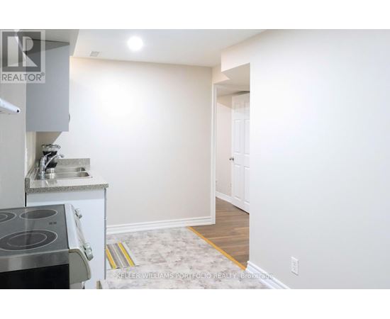 A kitchen with a stove top oven and sink.