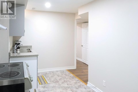 A kitchen with a stove top oven and sink.