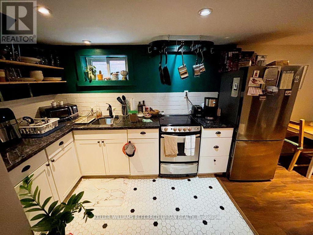 A kitchen with white cabinets and a black counter top.
