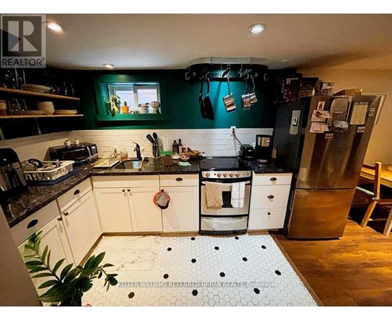 A kitchen with white cabinets and a black counter top.