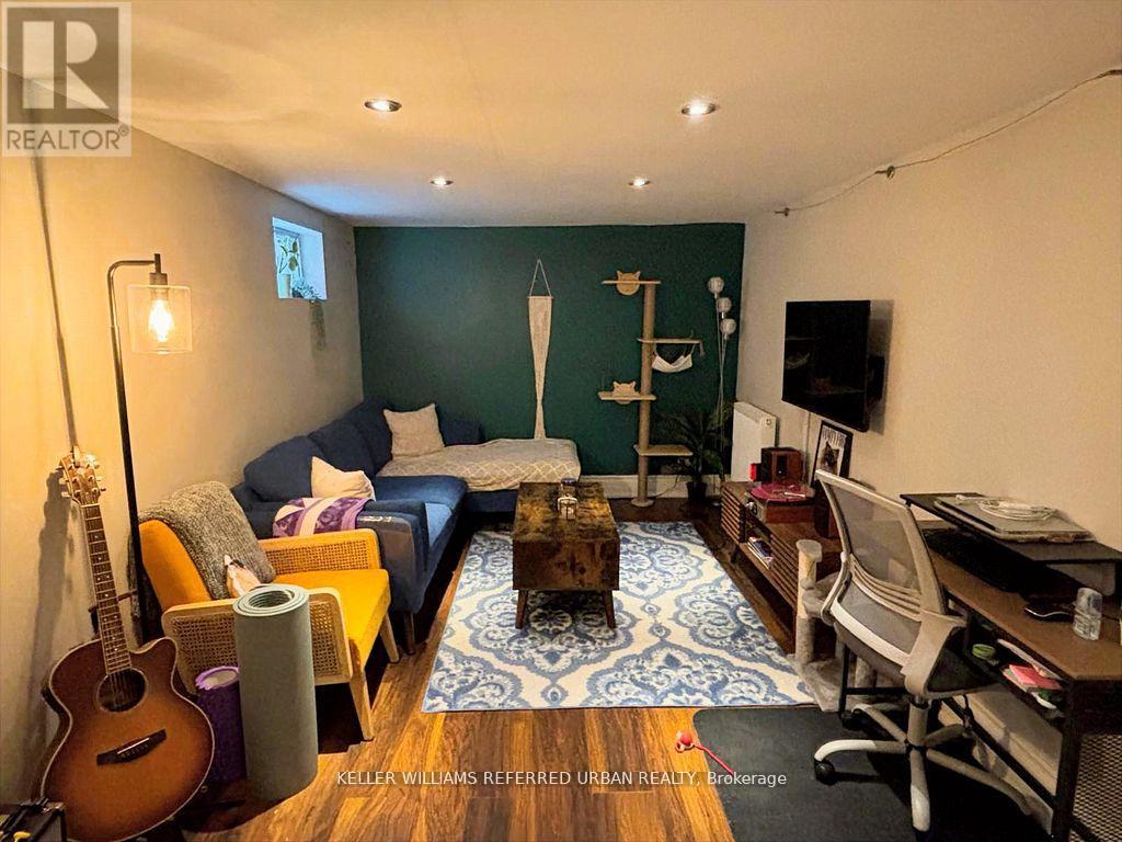 A living room with a guitar, a couch, a coffee table, and a TV.