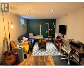 A living room with a guitar, a couch, a coffee table, and a TV.