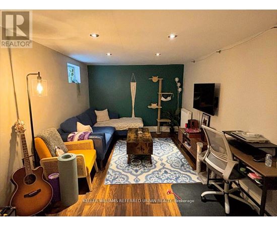 A living room with a guitar, a couch, a coffee table, and a TV.