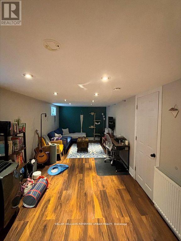 A living room with a wooden floor and a white ceiling.