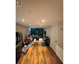 A living room with a wooden floor and a white ceiling.