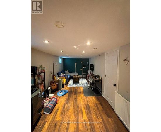 A living room with a wooden floor and a white ceiling.