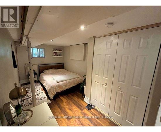 A bedroom with a bed, a chair, and a table.