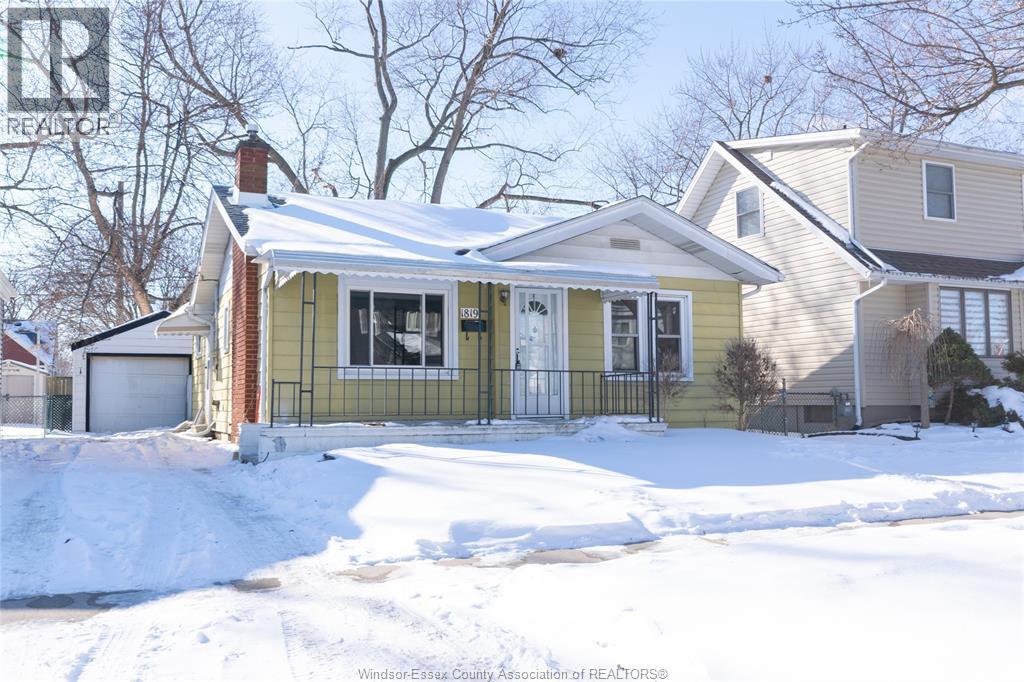 A house with a snow-covered ground in front of it.