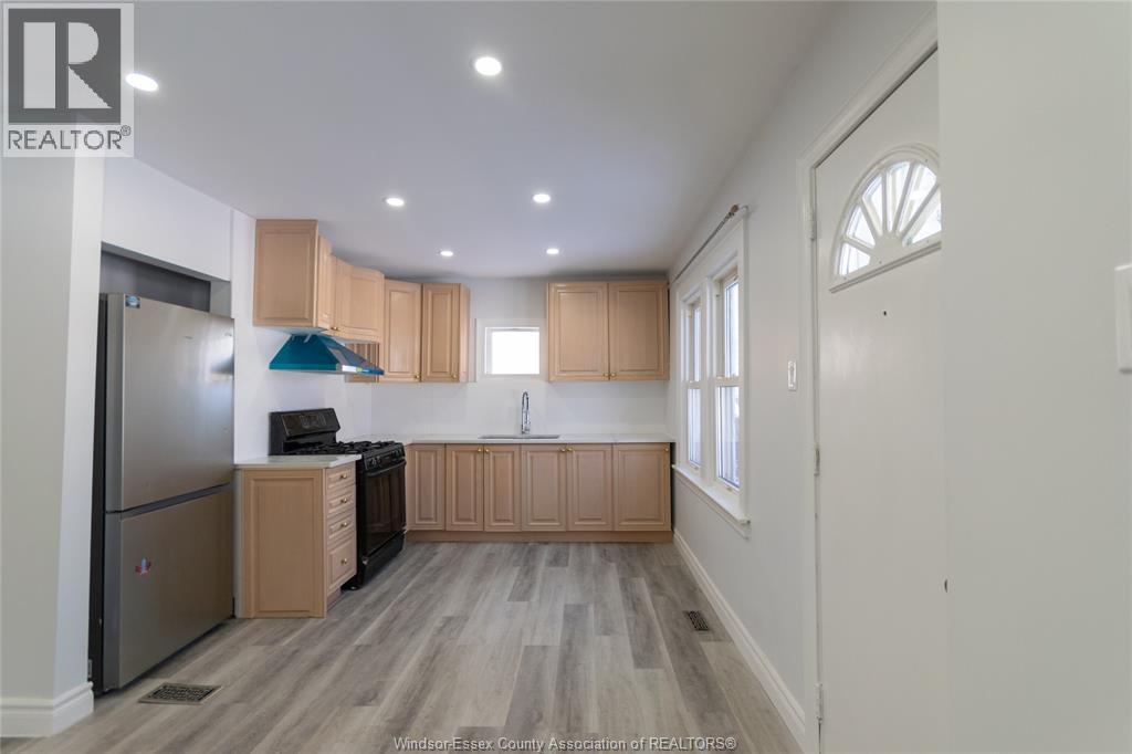 A kitchen with wooden cabinets and a refrigerator.