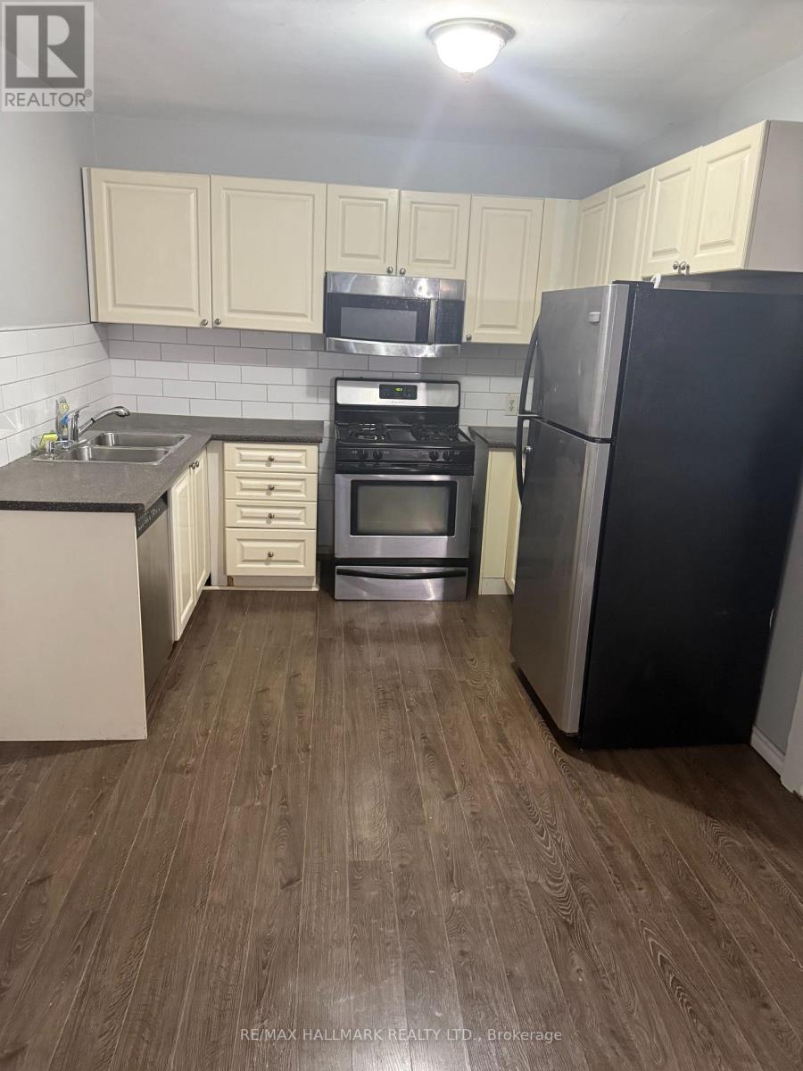 A kitchen with a black fridge and stove top oven.