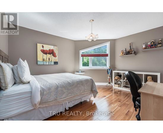 A bedroom with a large bed and a painting of a bird on the wall.