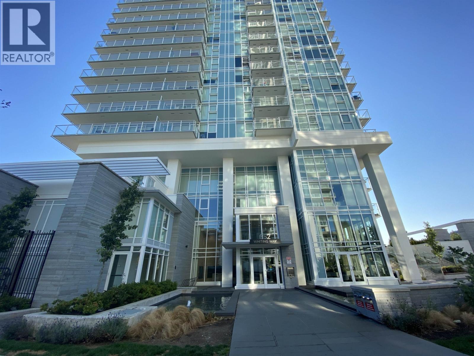 A tall building with a glass facade and a sign that says REALTOR.
