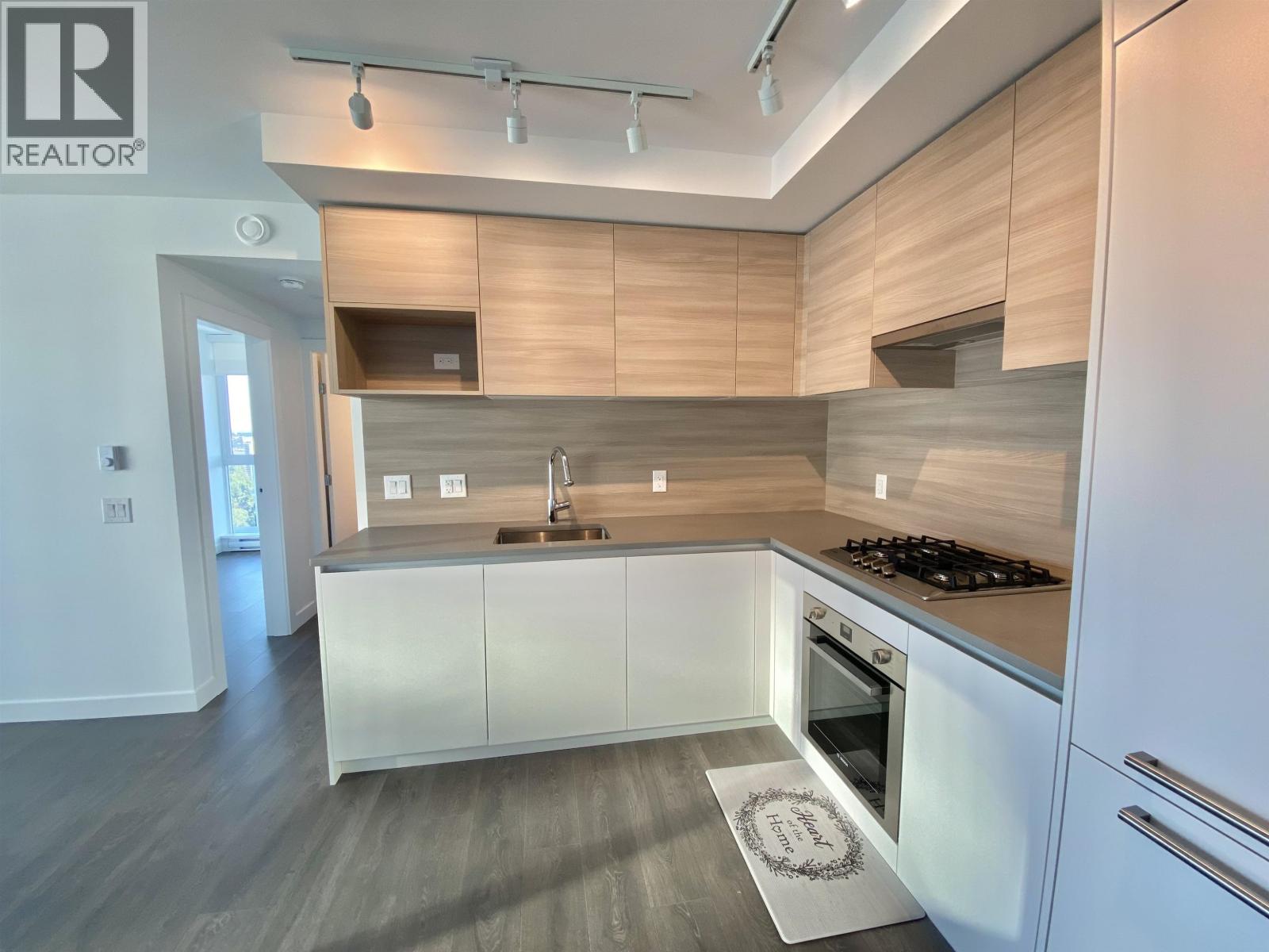 A modern kitchen with white cabinets and a wooden backsplash.