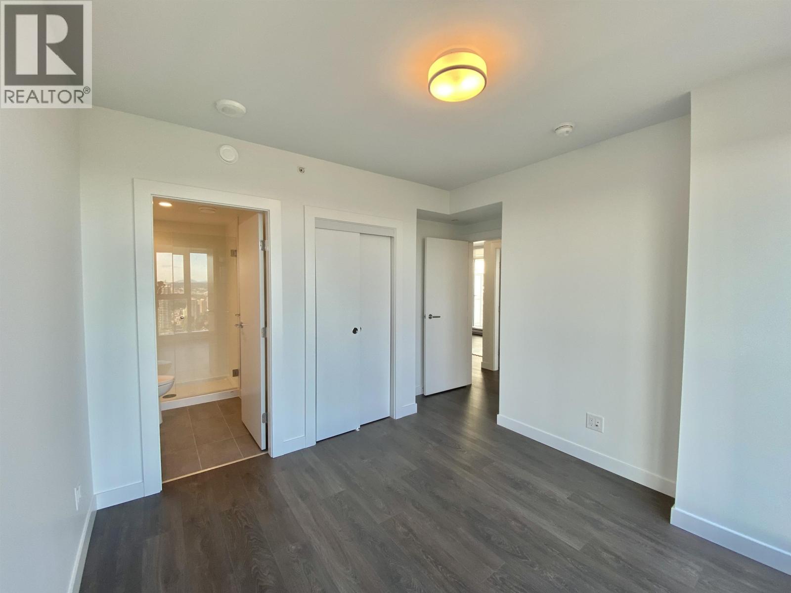 A spacious room with a doorway leading to another room.