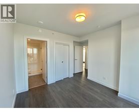 A spacious room with a doorway leading to another room.