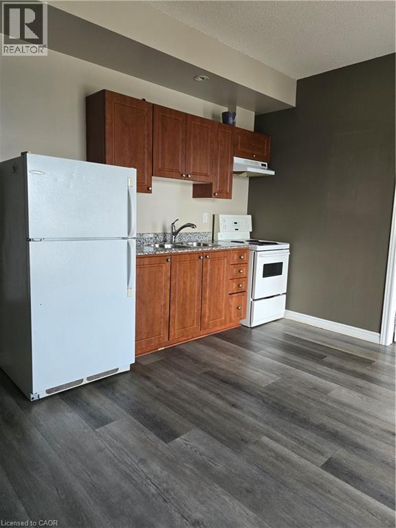 A kitchen with a white fridge and wooden cabinets.