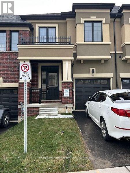 A white car is parked in front of a house with a no parking sign.