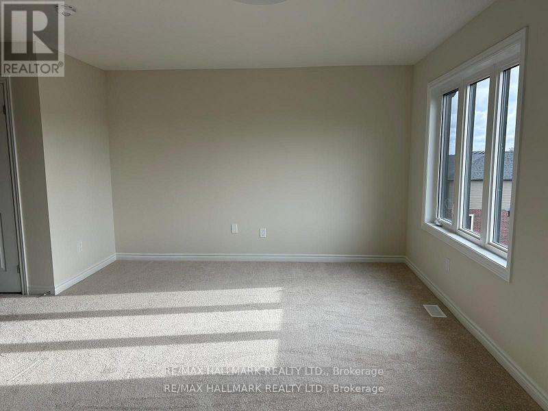 A room with a carpeted floor and a window letting in sunlight.