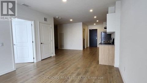 A spacious living room with a television and hardwood floors.