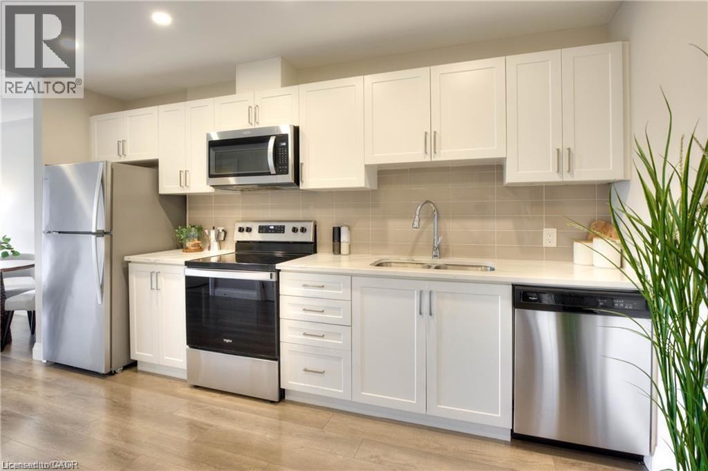 A modern kitchen with white cabinets and stainless steel appliances.