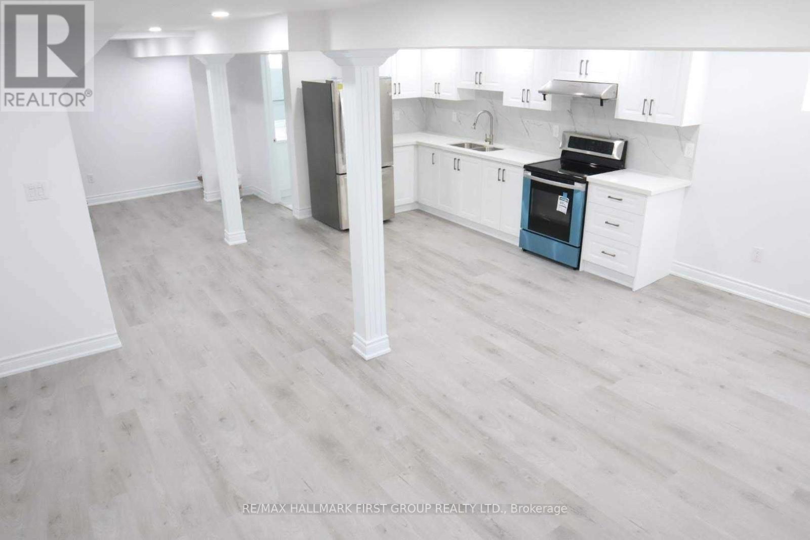 A spacious kitchen with white cabinets and a blue oven.