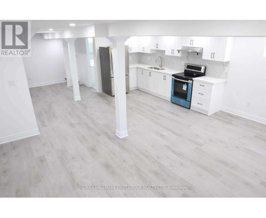 A spacious kitchen with white cabinets and a blue oven.