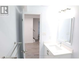A bathroom with a sink, mirror and a door.