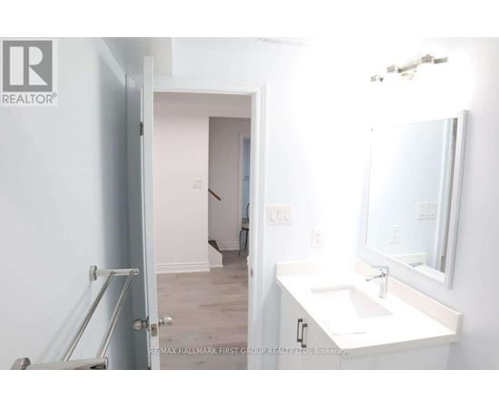 A bathroom with a sink, mirror and a door.