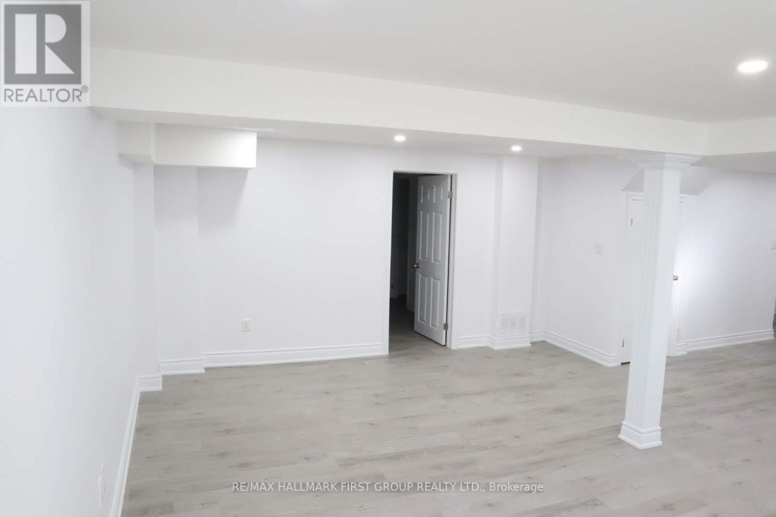 A spacious room with a doorway leading to another room.